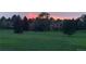 Dusk scene features park grass and trees with the sun setting in the background at 5046 S Evanston St, Aurora, CO 80015