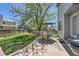 Concrete patio features an outdoor table and chairs, a BBQ and a backyard with green grass at 5046 S Evanston St, Aurora, CO 80015
