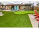 Backyard featuring a putting green, lounge chairs, batting cage and outdoor bar at 11964 W 71St Pl, Arvada, CO 80004