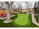 Backyard with a putting green, gazebo, lounge chairs and mature tree at 11964 W 71St Pl, Arvada, CO 80004