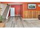 Open basement space with stairs, refrigerator, wine rack and wood paneling at 11964 W 71St Pl, Arvada, CO 80004