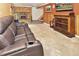 Basement Gathering room with wood paneled walls, comfortable seating and fireplace at 11964 W 71St Pl, Arvada, CO 80004