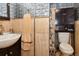 Traditional bathroom featuring tile walls, sink, toilet and dark brown cabinetry at 11964 W 71St Pl, Arvada, CO 80004