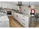 Bright, renovated kitchen featuring white cabinetry, sleek hardware, and a large island with cooktop at 11964 W 71St Pl, Arvada, CO 80004