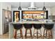 Gourmet kitchen with stainless steel appliances, a large island with bar seating, and modern fixtures at 11964 W 71St Pl, Arvada, CO 80004