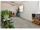 Bright living room with neutral walls, gray carpet, plants and a large window for natural light at 11964 W 71St Pl, Arvada, CO 80004