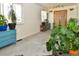 Bright and airy living room with large windows, blue dresser and plenty of plants at 11964 W 71St Pl, Arvada, CO 80004