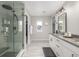 Bright bathroom featuring a glass shower, double vanity, modern lighting, and access to a walk-in closet at 4925 Coltin Trl, Castle Rock, CO 80104