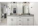 Modern bathroom with double vanity, gray countertops, and two mirrors with stylish lighting at 4925 Coltin Trl, Castle Rock, CO 80104