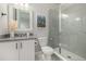 Modern bathroom featuring a gray vanity, framed mirror, toilet, and a glass-enclosed tiled shower at 4925 Coltin Trl, Castle Rock, CO 80104