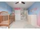 A charming Bedroom with a wooden crib, changing table, and playful decor on blue and pink walls at 4925 Coltin Trl, Castle Rock, CO 80104