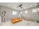 Well-lit bonus room featuring a modern sofa, a play area, and natural light from multiple windows at 4925 Coltin Trl, Castle Rock, CO 80104