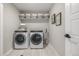 Well-organized laundry room with modern washer and dryer, shelving, and stylish decor at 4925 Coltin Trl, Castle Rock, CO 80104