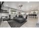 Open-concept living room with large windows, a ceiling fan, and views into the kitchen at 4925 Coltin Trl, Castle Rock, CO 80104