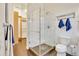 Bright bathroom featuring a glass shower, modern toilet, and storage closet at 1521 Central St # 3C, Denver, CO 80211