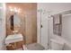 Inviting bathroom showcasing a glass shower, oval mirror, modern sink, and stylish lighting at 1521 Central St # 3C, Denver, CO 80211