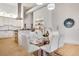 Bright dining area with a glass table, white chairs, and an open view into the kitchen at 1521 Central St # 3C, Denver, CO 80211