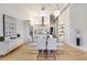 Open-concept living area with modern dining table, stylish buffet, and light wood floors at 1521 Central St # 3C, Denver, CO 80211