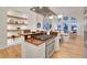 Open kitchen with stainless steel appliances, wooden shelves, and views of the living room at 1521 Central St # 3C, Denver, CO 80211