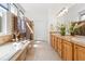 Bathroom featuring a soaking tub, tiled shower, and double vanity with abundant natural light at 7120 Red Mesa Dr, Littleton, CO 80125