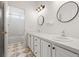 Well-lit bathroom with dual sinks, modern fixtures, and tile floors at 7120 Red Mesa Dr, Littleton, CO 80125