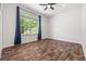 Bright bedroom featuring hardwood floors and a large window with blue curtains at 7120 Red Mesa Dr, Littleton, CO 80125