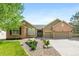 Beautiful, well-maintained home showcasing a manicured front yard, brick accents, and attached two car garage at 7120 Red Mesa Dr, Littleton, CO 80125