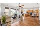 Open-concept living area with hardwood floors, large windows, and views of the eat in kitchen and dining area at 7120 Red Mesa Dr, Littleton, CO 80125