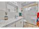 Bathroom featuring marble-look vanity, tiled shower with gold trim, and decorative mirror at 7940 Appleblossom Ln, Westminster, CO 80030