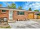 Close up of a charming brick home, showing the front door and attached garage at 7940 Appleblossom Ln, Westminster, CO 80030