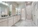 Well-lit bathroom featuring double sinks, white cabinets, and a walk-in shower at 91 Greeley Blvd, Palmer Lake, CO 80133
