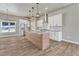 Contemporary kitchen featuring white cabinets, stainless steel appliances, a center island, and wood-look tile floors at 91 Greeley Blvd, Palmer Lake, CO 80133