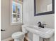 Powder room with a white pedestal sink, modern fixtures, and a window at 91 Greeley Blvd, Palmer Lake, CO 80133