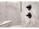 Elegant shower featuring marble-style tiling, a built-in seat, and stylish matte black fixtures at 91 Greeley Blvd, Palmer Lake, CO 80133