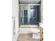 Well-lit bathroom with glass enclosed shower and tub featuring blue subway tile at 7154 S Hudson Cir, Centennial, CO 80122