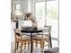 Sunlit dining area with wood flooring, a round table, and stylish chairs, adjacent to the modern kitchen at 7154 S Hudson Cir, Centennial, CO 80122