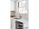 Close-up of the kitchen sink area featuring white countertops, gold hardware, and a bright window view at 7154 S Hudson Cir, Centennial, CO 80122
