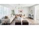 Bright living room featuring shuttered windows, neutral furniture, an elegant chandelier, and a stylish area rug at 7154 S Hudson Cir, Centennial, CO 80122
