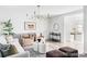 Airy living room offers a sophisticated chandelier, stylish furniture, and seamless transition to the adjacent kitchen at 7154 S Hudson Cir, Centennial, CO 80122