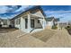 Backyard view of the home featuring a patio, xeriscaping, and a covered porch with sliding glass doors at 6634 N Malta St, Aurora, CO 80019