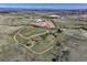 Expansive aerial view of horse property, rolling hills, trails, barns, and mountain views at 1705 Outter Marker Rd, Castle Rock, CO 80108