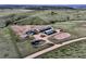 An aerial shot showcases a horse property, revealing its barns, paddocks, equestrian facilities, and expansive land at 1705 Outter Marker Rd, Castle Rock, CO 80108