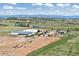 This aerial image captures the horse property with multiple outbuildings, fenced paddocks, and picturesque mountain views at 1705 Outter Marker Rd, Castle Rock, CO 80108