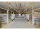 This well-lit barn interior features a central aisle with numerous stalls along both sides at 1705 Outter Marker Rd, Castle Rock, CO 80108