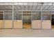 This image shows several horse stalls, each with wood paneling and metal bars at 1705 Outter Marker Rd, Castle Rock, CO 80108