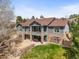 Elegant gray two-story home featuring a stone base, balcony, and inviting outdoor patio with lush lawn at 7003 S Irvington Ct, Aurora, CO 80016