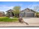 Charming gray home featuring a manicured lawn, stone accents, and a two-car garage at 7003 S Irvington Ct, Aurora, CO 80016