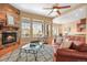 Cozy living room featuring a stone fireplace, large windows, and comfortable seating area at 7003 S Irvington Ct, Aurora, CO 80016