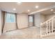 Expansive basement area with plush carpeting, recessed lighting, and natural light from two windows at 9422 E 58Th Pl, Denver, CO 80238