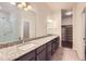 Bathroom with a double vanity, granite countertops, and a glass-enclosed shower and walk-in closet at 9422 E 58Th Pl, Denver, CO 80238